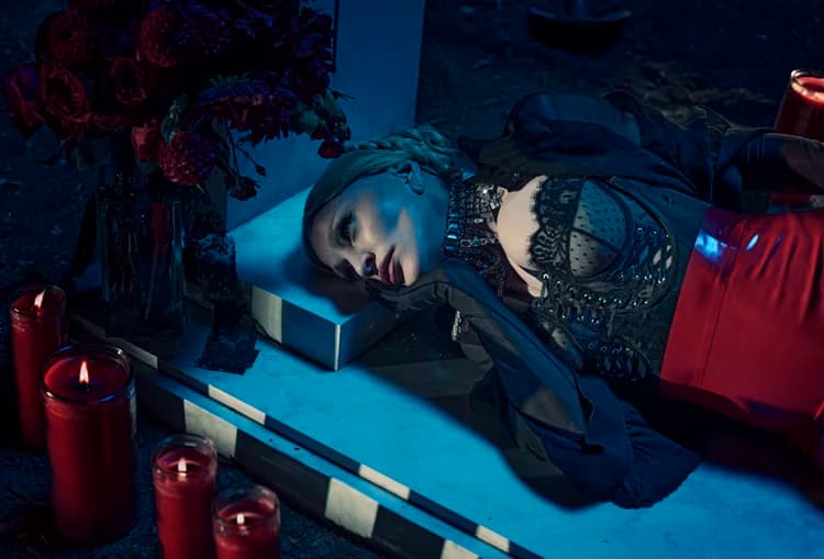 Moody fashion set with a marble tombstone, flowers and red candles.