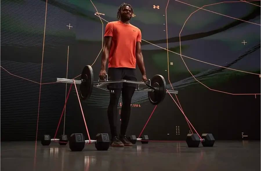 An athlete lifting a barbell on a gym production set with a digital backdrop.