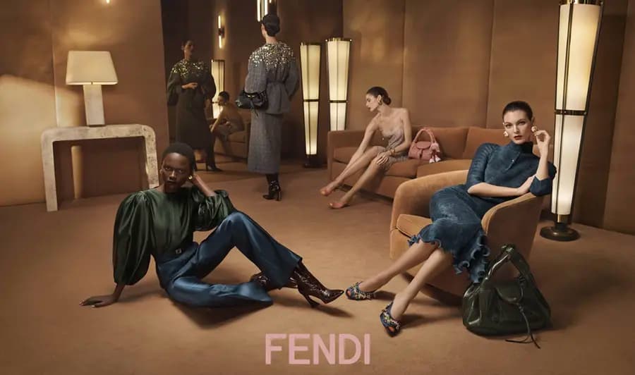 A warm-toned Fendi campaign set with models, furniture, and modern lamps.